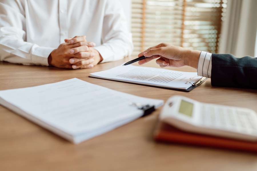 Conseiller en assurance pour particuliers présentant un contrat à signer au client lors d'une réunion professionnelle