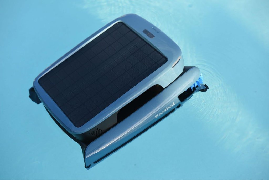 Robot piscine Beatbot flottant dans l'eau bleue avec panneau solaire intégré