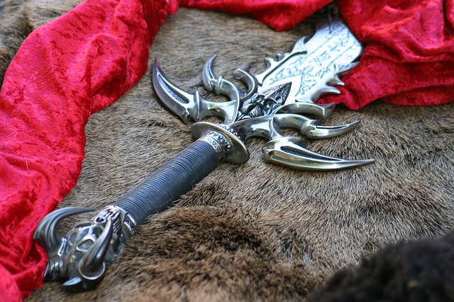 Épée fantastique argentée repose sur une fourrure brune et un tissu rouge.