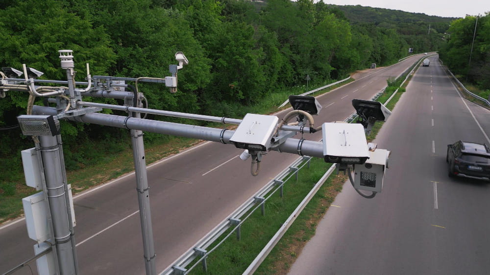 Dispositif de radars antibruit installés sur un portique au-dessus d'une route départementale en lisière de forêt