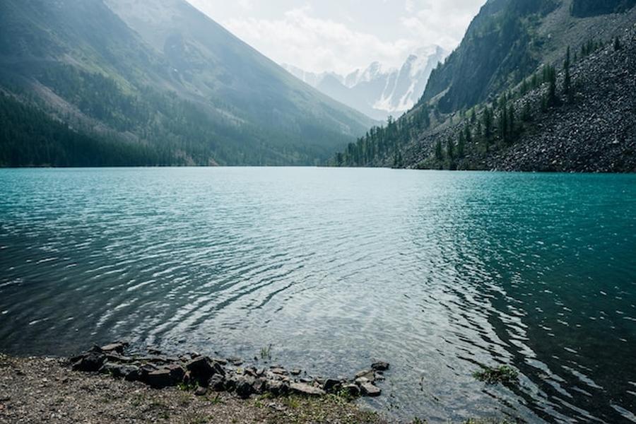 Eaux turquoise cristallines d'un paisible mountain lake entouré de sommets escarpés.