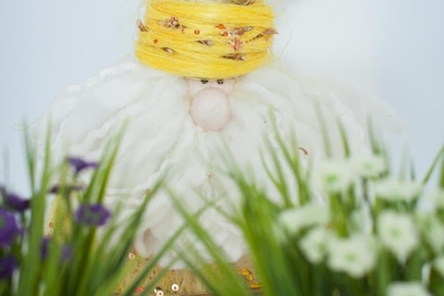 Un personnage bienveillant à la barbe blanche et coiffe jaune niché dans la végétation illustrant les bienfaits des postbiotiques naturels : l'allié de la clarté mentale et de l'immunité.