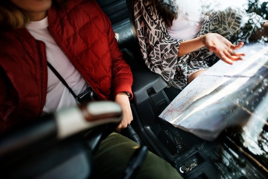 Deux voyageurs consultent une carte routière à l'intérieur de leur véhicule, une étape illustrée dans ce Guide complet pour organiser un road trip en van électrique à travers la Scandinavie.