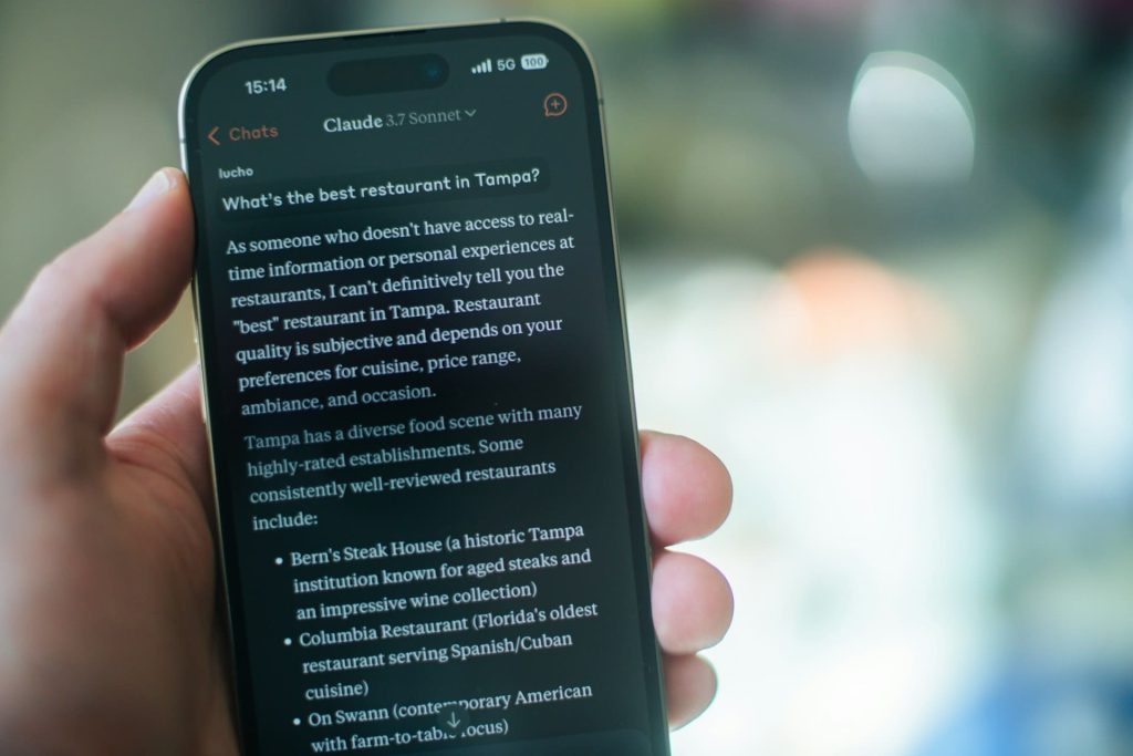 Gros plan sur un smartphone affichant une conversation avec un assistant conversationnel, une étape clé pour tout guide IA débutants.