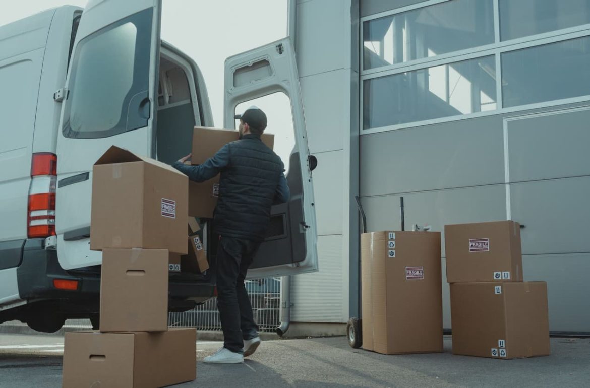 Un professionnel chargeant des cartons sur un diable près d'un camion blanc pour illustrer le tarif déménagement professionnel.