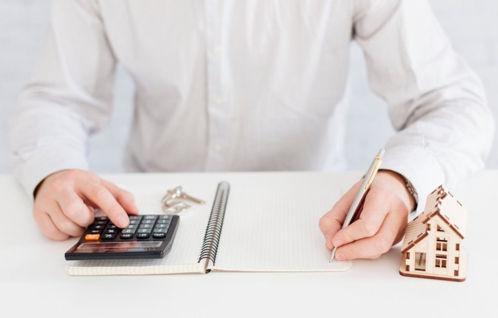 Un acheteur calcule son budget immobilier avec une calculatrice selon le guide complet prix ac.