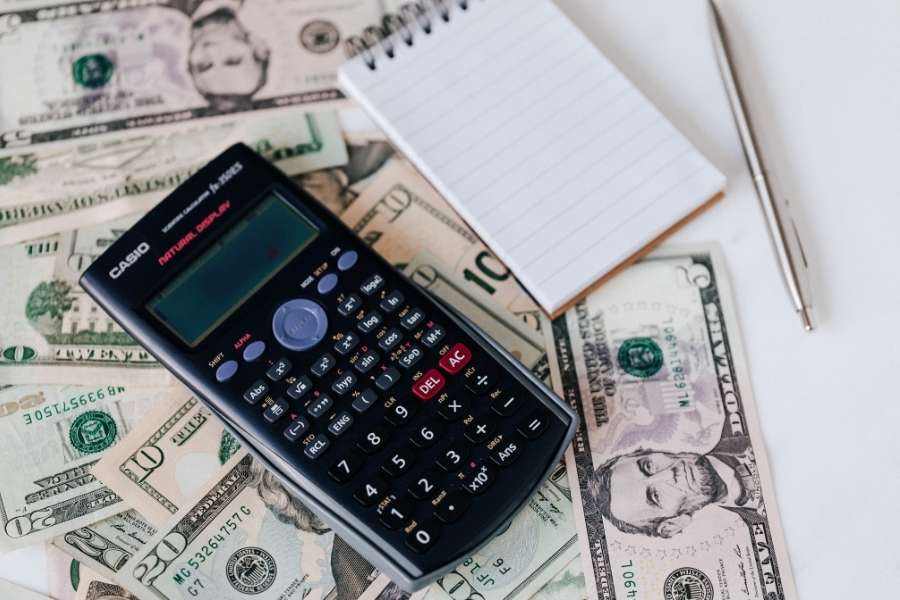 Une calculatrice posée sur des billets de banque dans le cadre de l'analyse de la convention fiscale France Hong Kong.
