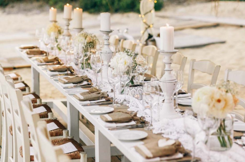 Table de réception de mariage champêtre sur le sable pour savoir comment calculer budget mariage sans se ruiner.